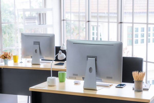 computers on desks in modern office work space