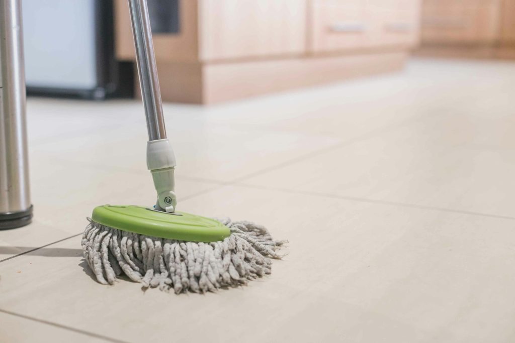 green mop on hard flooring in business